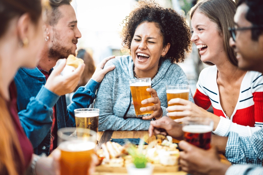 group of friends at a brewery laughing and enjoying beer together